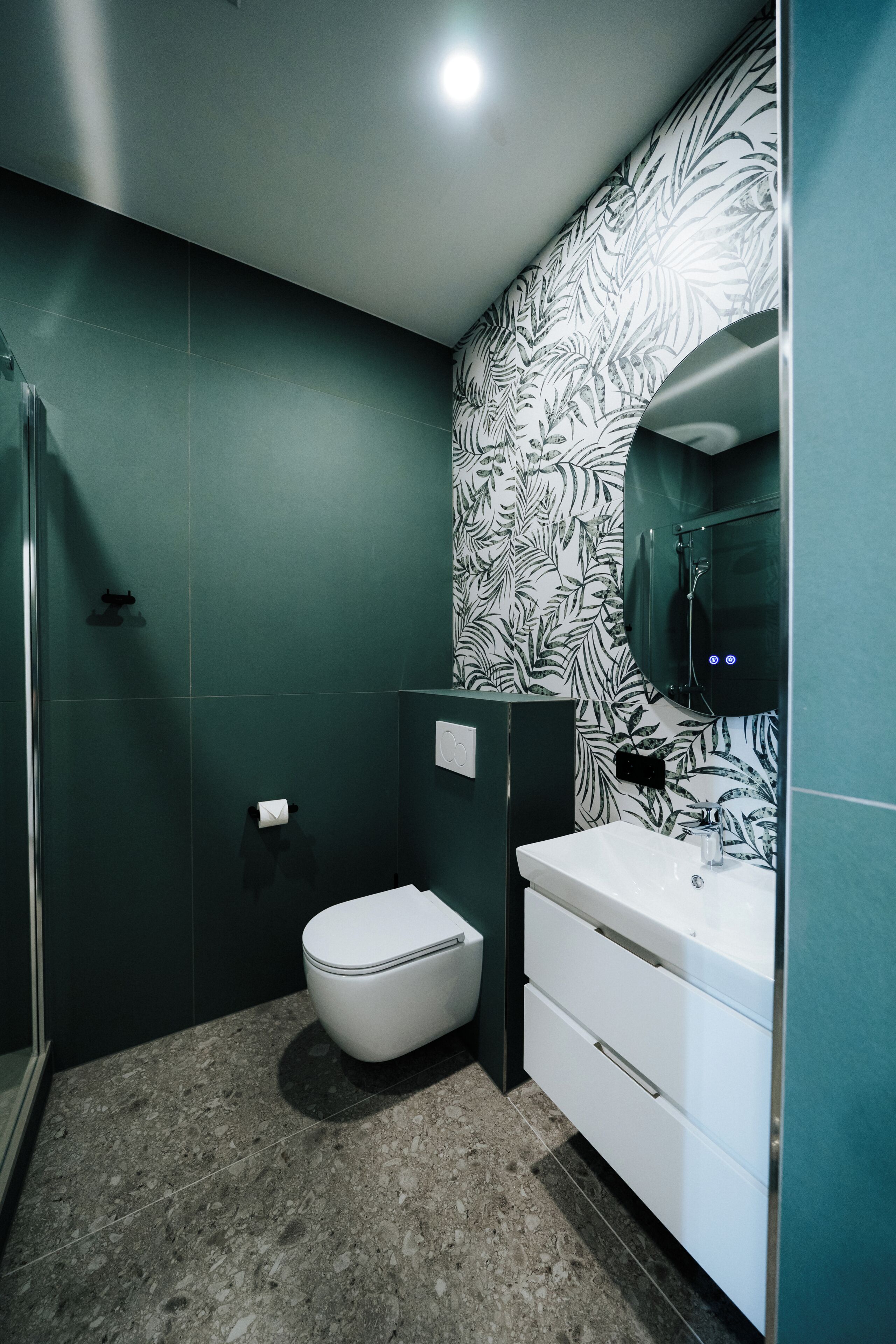 A modern bathroom with a toilet, sink, and shower.