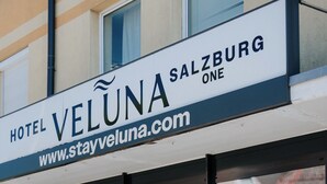 A hotel sign with the name 'Hotel Veluna Salzburg One' and a website address.