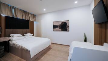 Una habitación de hotel moderna con una cama, una mesita de noche y un televisor montado en la pared.