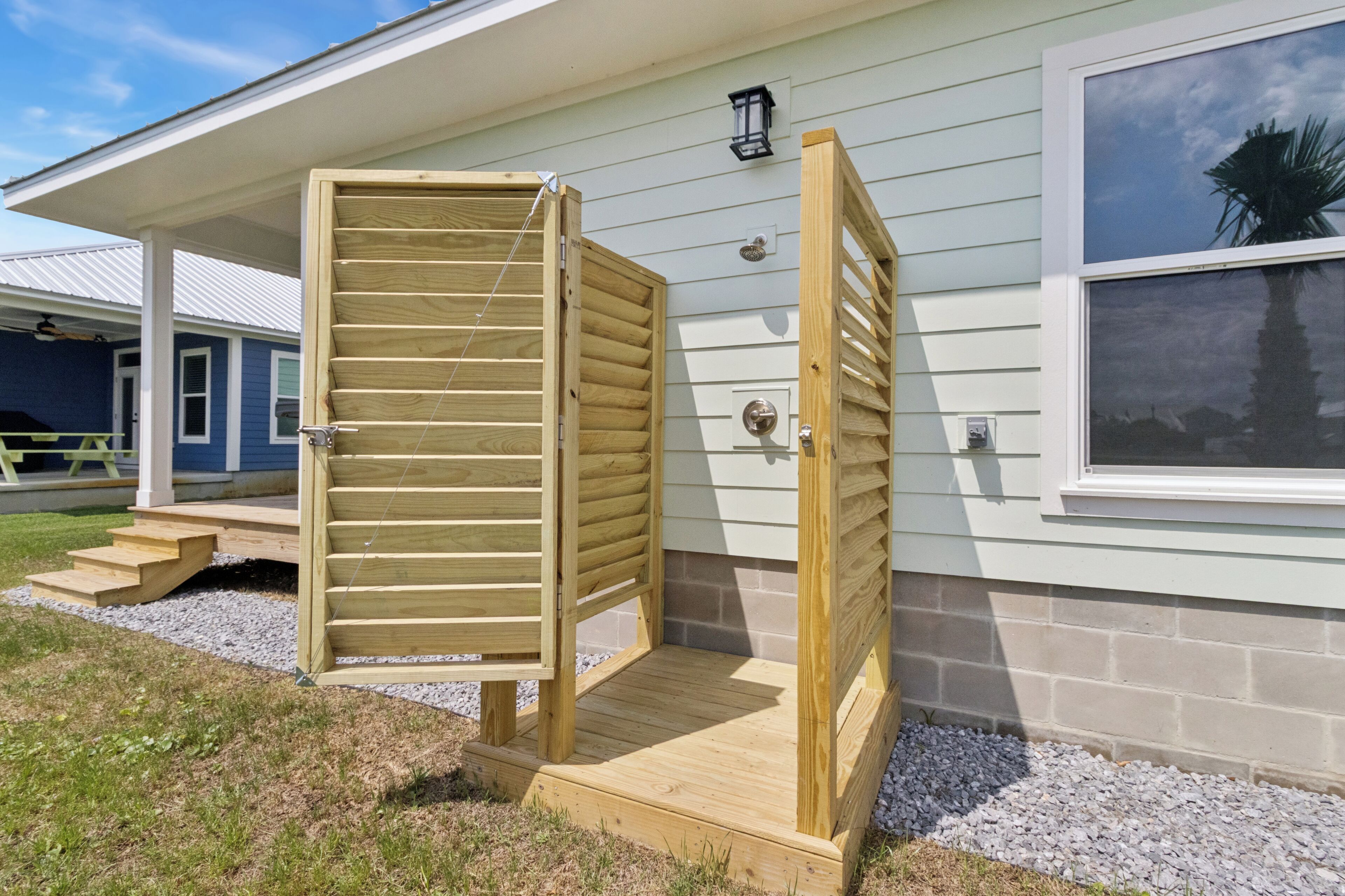 Une porte en bois avec une marche menant à une maison dotée d’une fenêtre et d’une porte.