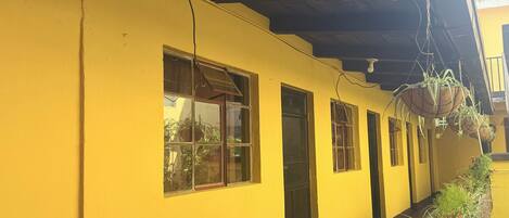 A yellow building with multiple windows and a covered walkway.