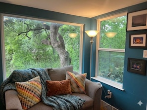 A room with a large window, a sofa with patterned cushions, and a floor lamp. - Modern Treehouse at UT ❤️ Walk to Football, Moody Centre | Free Parking (Austin)