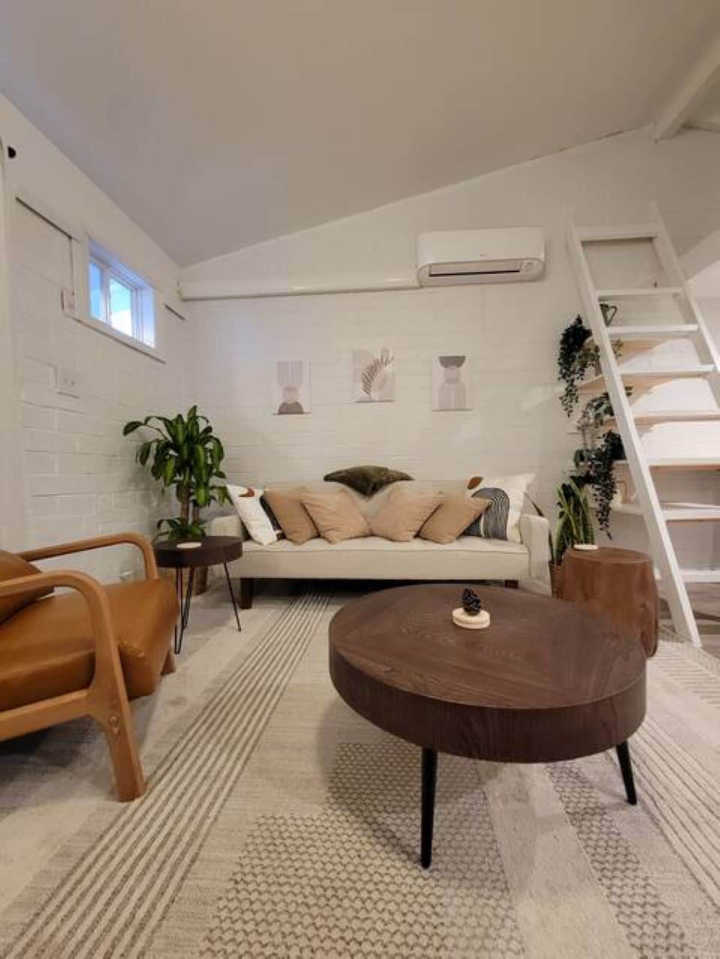 A modern living room with a sofa, coffee table, and a staircase.