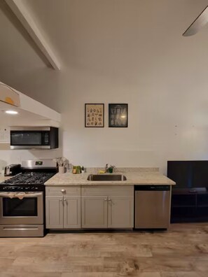 A modern kitchen with stainless steel appliances, a built-in dishwasher, and a microwave. - Cedar Loft · FIFA Stay · Private Parking (Atlanta)