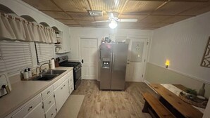 Eine Küche mit Kühlschrank, Herd, Spüle und Holzboden.