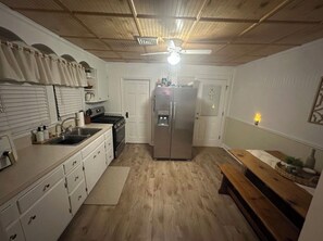 Eine Küche mit Kühlschrank, Herd, Spüle und Holzboden.