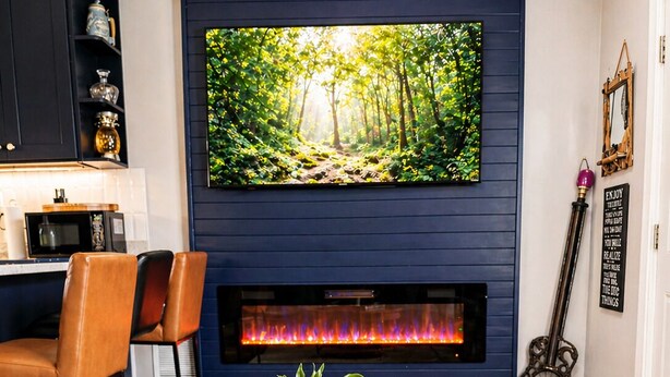 Un salon moderne avec une cheminée, un téléviseur fixé au mur et une table basse ronde en bois sur laquelle est posée une plante en pot.