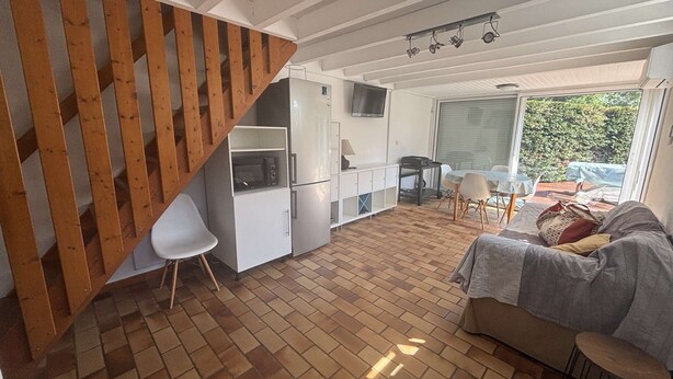 A compact living space with a kitchen, dining area, and a sofa. - Vacances proches du lac ! (BISCARROSSE)