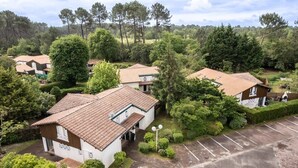 A residential area with multiple houses, each with a tiled roof and surrounded by greenery. - Vacances proches du lac ! (BISCARROSSE)