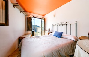 A bedroom with a bed, a nightstand, a window with a view, and a balcony. - 3 bedroom amazing home in Berchules (Berchules)