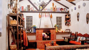 A cozy room with a fireplace, wooden furniture, and various decorations.