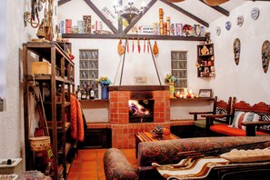 Une pièce chaleureuse avec une cheminée, des meubles en bois et diverses décorations.