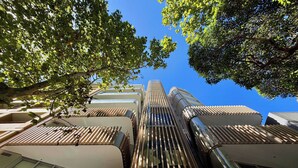 Een modern gebouw met een opvallend schuin dak, omringd door bomen.