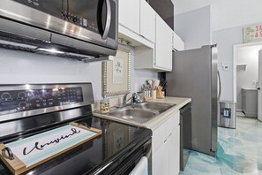 Eine moderne Küche mit Edelstahlgeräten, einem Backofen, einer Spüle und einem Kühlschrank.