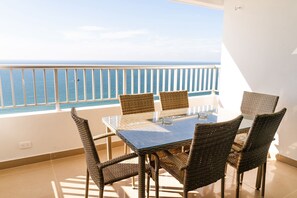 A balcony with a glass table and wicker chairs, overlooking the sea. - Ven y disfruta de tus mejores vacaciones frente al mar, (Cartagena de Indias)