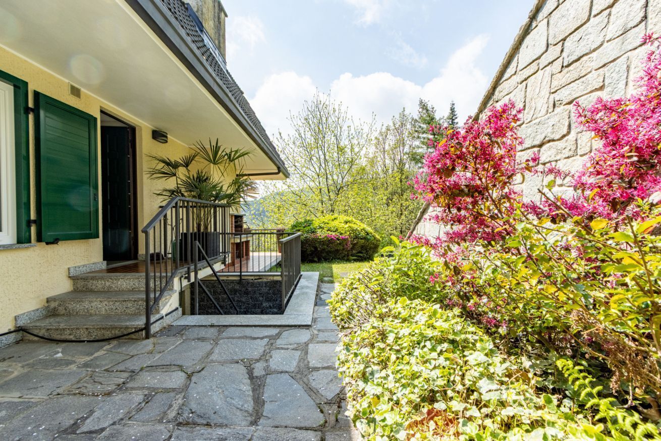 A stone staircase leading to a building with a green door and a small porch.