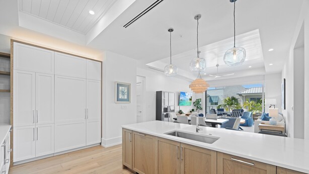 A modern kitchen with a large island, wooden cabinets, and pendant lighting. - 🌴 Olde Naples Luxury at The Mark | Walk to Beach + 5th Ave | Weekly Stays | Resort Pool & Spa (Naples)