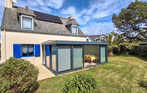 A modern house with a glass conservatory, a sloped roof, and a well-maintained lawn. - 3 bedroom cozy home in Trégunc (Trégunc)