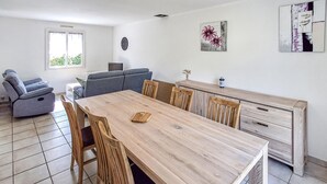 Une cuisine moderne avec une table en bois, des chaises, un canapé et un coin repas.