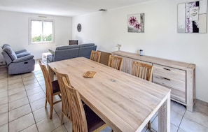 A modern kitchen with a wooden table, chairs, a sofa, and a dining area. - 3 bedroom cozy home in Trégunc (Trégunc)