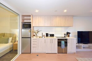 Eine moderne Küche mit Kühlschrank, Mikrowelle, Herd und Spüle. Es gibt einen Essbereich mit Tisch und Stühlen.