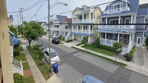 A residential street with houses, cars, and a sidewalk. - Bright & Welcoming 2BR Near Beach, Boardwalk & Local Attractions (Ocean City)