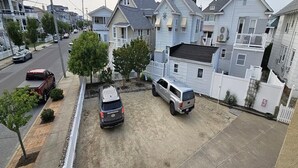 A residential area with houses, a driveway, and parked vehicles. - Bright & Welcoming 2BR Near Beach, Boardwalk & Local Attractions (Ocean City)