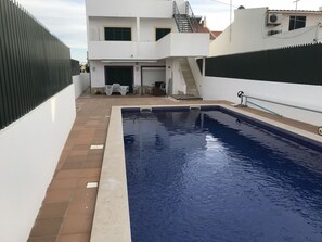Ein Schwimmbecken mit einem weißen Gebäude im Hintergrund.