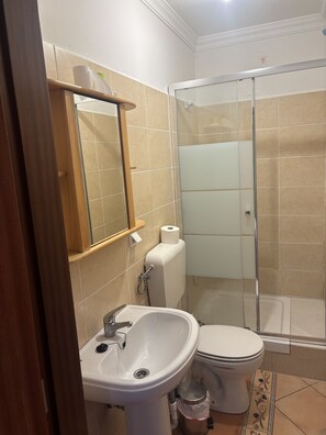 A bathroom with a sink, toilet, and glass shower enclosure. - Altura verde apartment (Altura)