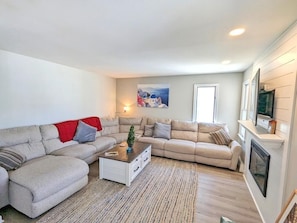 Ein Wohnzimmer mit zwei Sofas, einem Couchtisch, einem Kamin und einem Gemälde an der Wand.