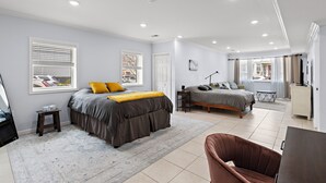 A bedroom with a large bed, a smaller bed, a desk, and a chair. - Massive 4-bedroom, 3-bathroom duplex apt with garage parking in Jersey City (Jersey City)