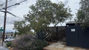 A residential area with a gated entrance, a wooden fence, and a street sign. - Hot Tub. A/C. Laundry. 2 Parking Spots. Orchard. (San Diego)