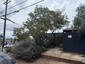 Un quartier résidentiel doté d’une entrée sécurisée par un portail, d’une clôture en bois et d’un panneau de signalisation.