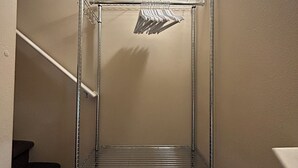 Ein Metallregal in einer Diele mit einer Treppe links.