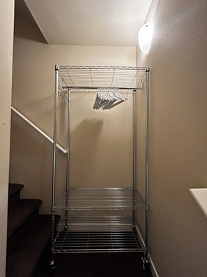 Ein Metallregal in einer Diele mit einer Treppe links.