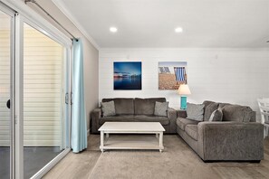 A living room with a sofa set, a coffee table, and two wall-mounted artworks. - Midtown OC Retreat | Ocean Block | Sleeps 10 (Ocean City)