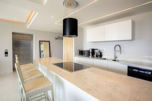 Una cucina moderna con isola centrale, elettrodomestici in acciaio inossidabile e un design minimalista.