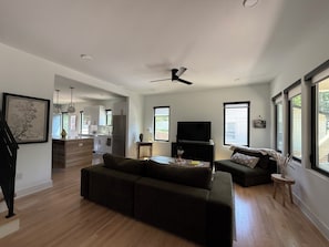 Un salon moderne avec un canapé, un téléviseur et un coin repas.