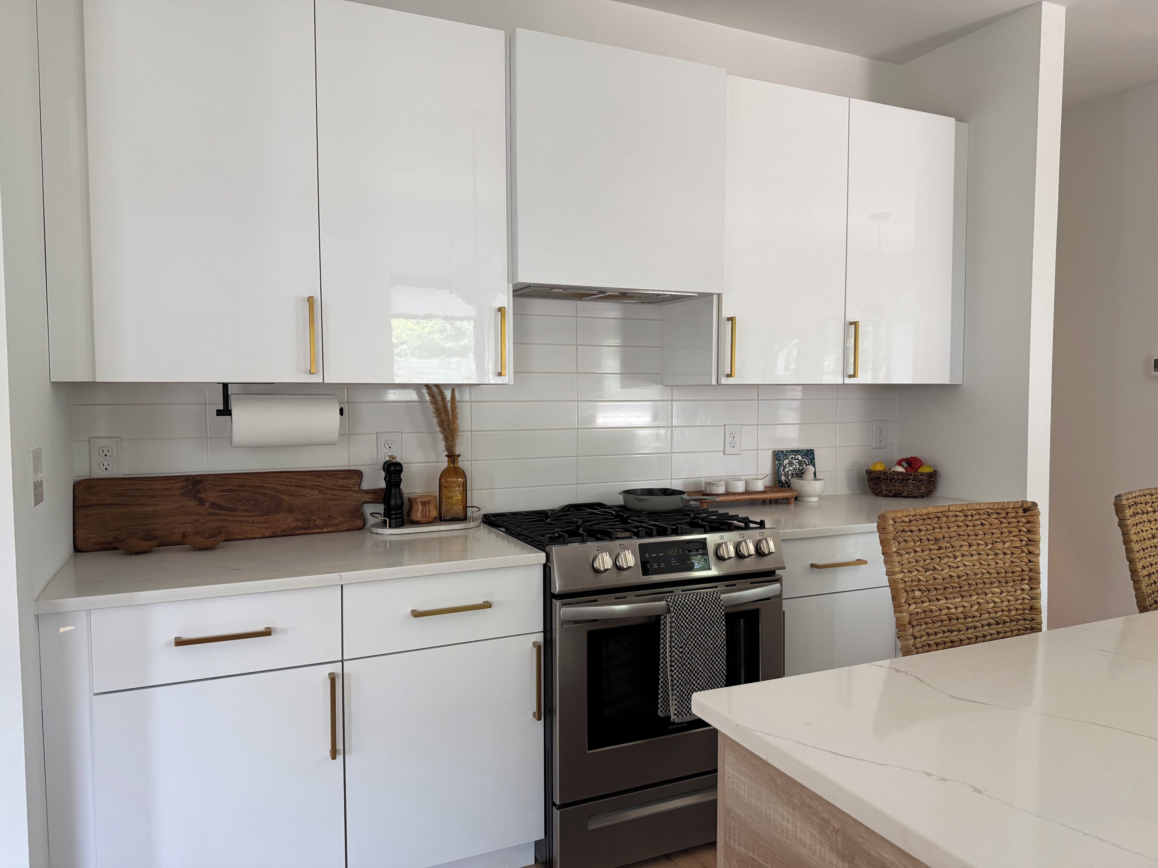 Une cuisine moderne avec des armoires blanches, des appareils en acier inoxydable et un plan de travail en bois.