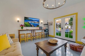 Una sala de estar moderna con una mesa de centro de madera, un sofá y un comedor con sillas.