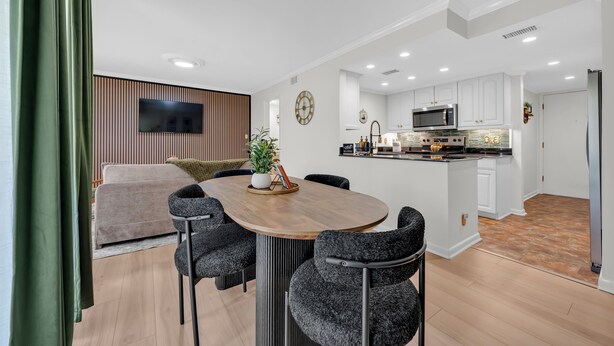 A modern kitchen with white cabinets, a microwave, and a refrigerator.