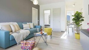 Ein modernes Wohnzimmer mit einer Couch, einem Couchtisch und einem Essbereich mit Stühlen.