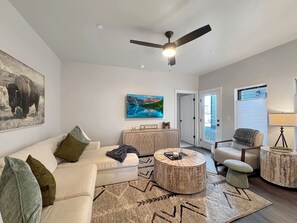 A living room with a sofa, coffee table, and armchair, a ceiling fan, and a painting on the wall. - Basecamp - Ski·Golf·Fish·Lake - Fire Table + Views (Granby)