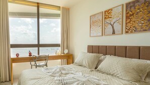 Ein Schlafzimmer mit Bett, Schreibtisch und Fenster mit Blick.