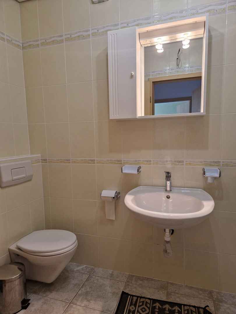 Une salle de bain avec des toilettes, un lavabo et un miroir.