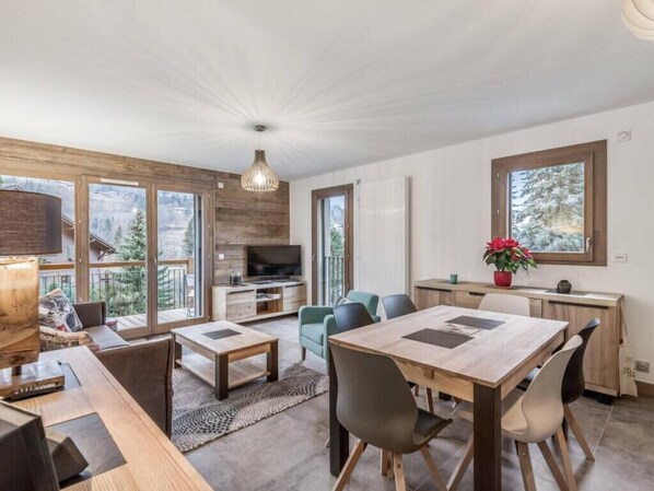 Ein modernes Interieur mit Essbereich, Sitzgelegenheiten und Blick ins Freie.