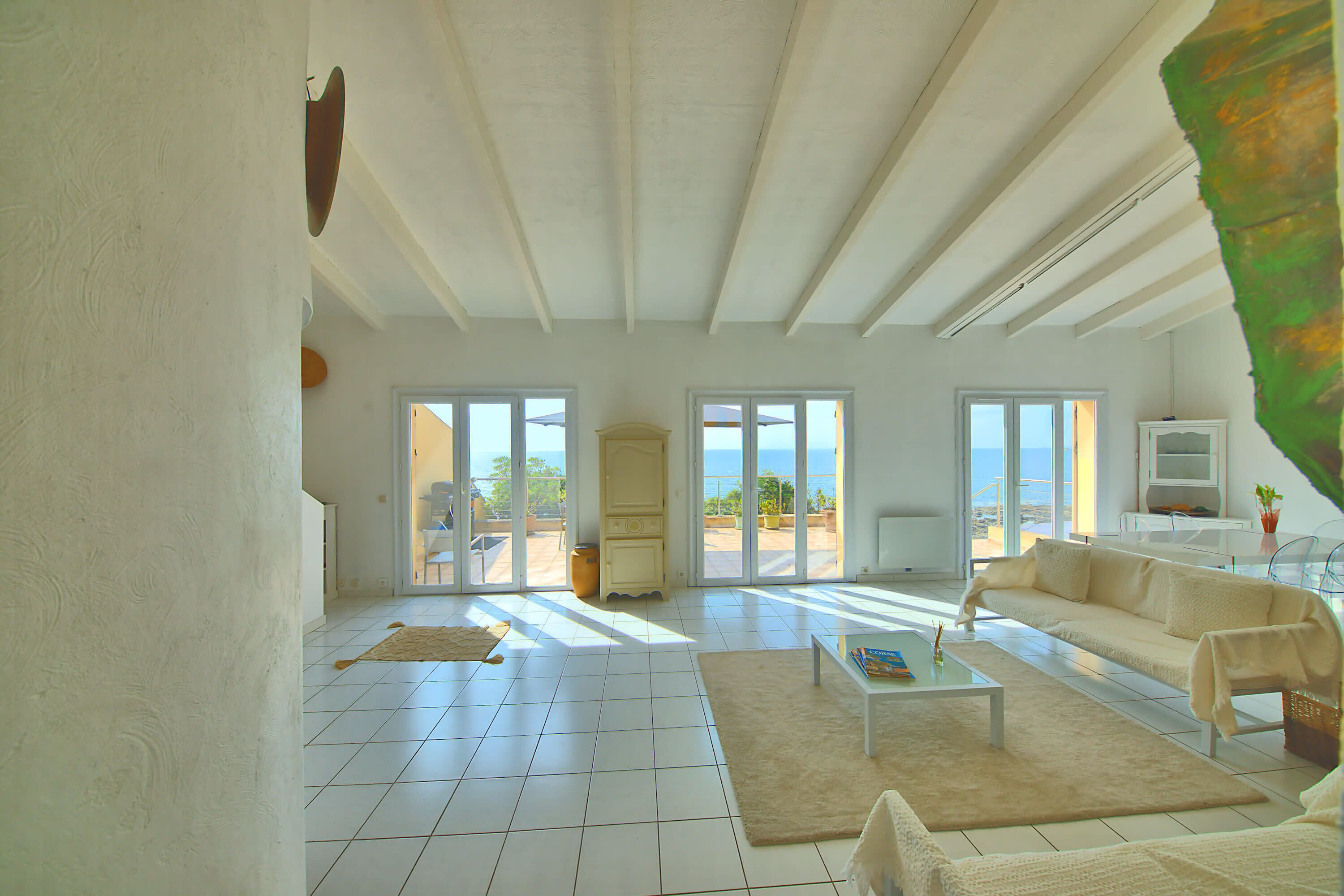 A spacious living area with a large sofa, a coffee table, and a television.