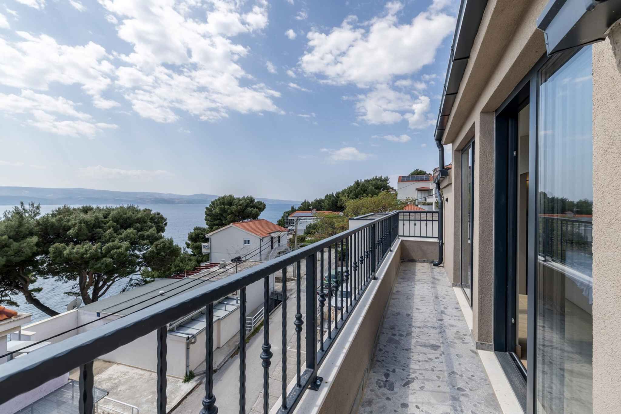 A balcony with a view of the sea and buildings.