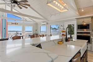 Cucina spaziosa con isola centrale ampia, elettrodomestici moderni e ampie finestre con vista.
