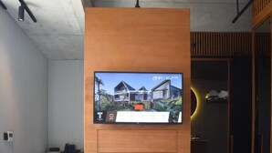 Un televisore montato su un pannello di legno con vista su un edificio moderno.